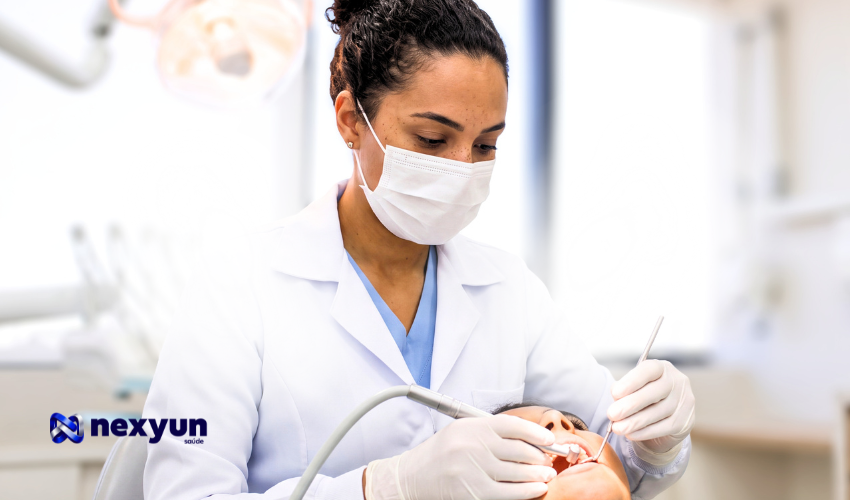 Dentista de máscara e jaleco atendendo paciente em consultório odontológico, ilustrando a escolha entre Amil Dental e Odontoprev